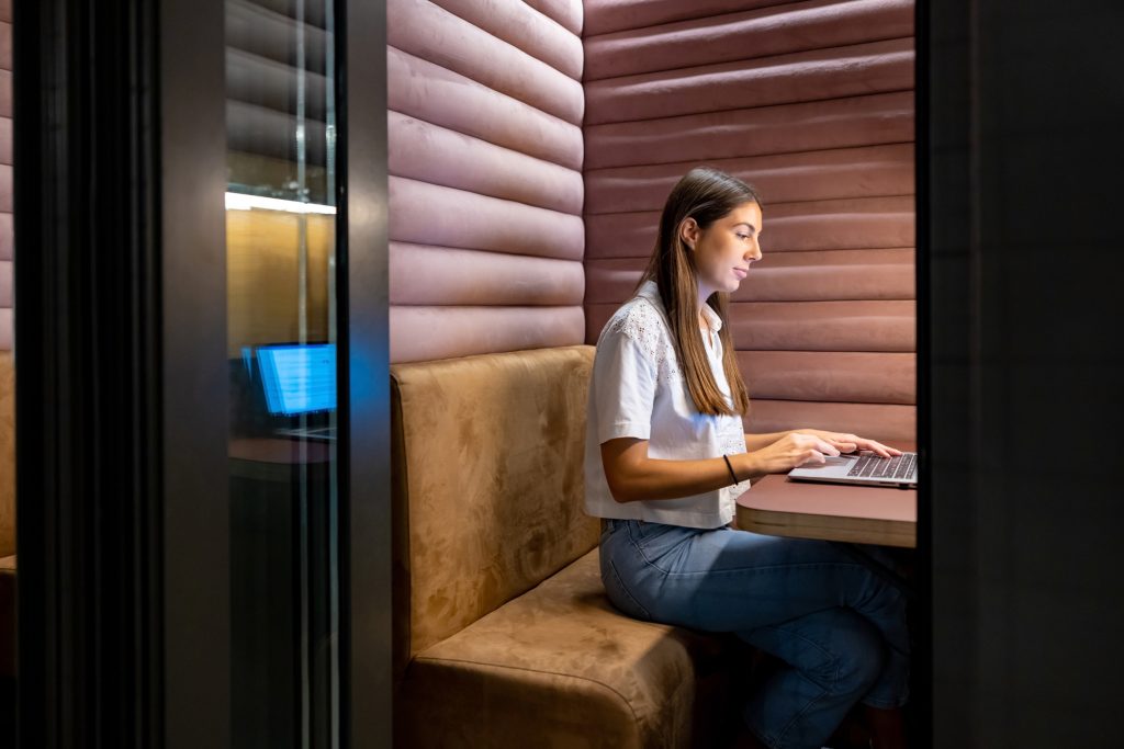 Business woman working in an isolated booth at an office