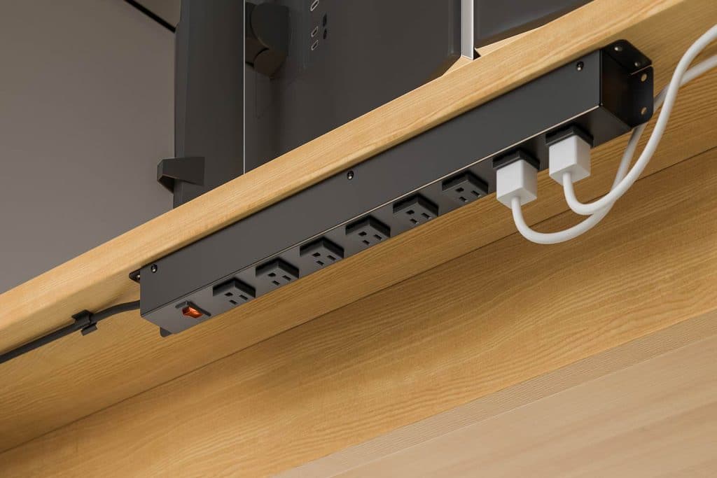 This photo shows a commercial grade power strip concealed under an office desk