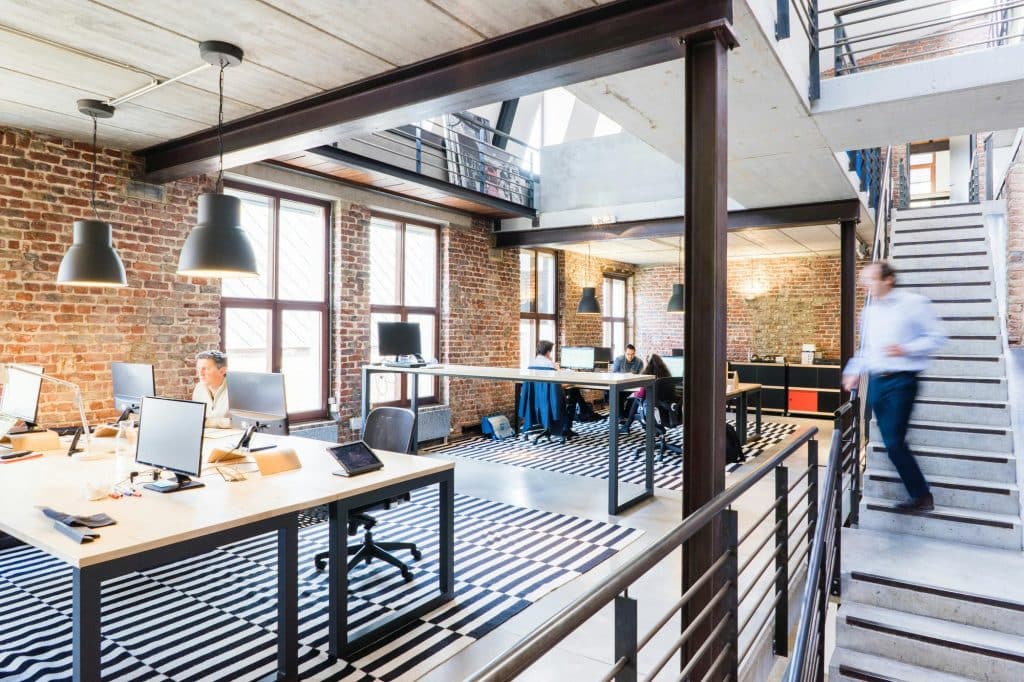 This photo features an open office space that uses modern office lighting fixtures