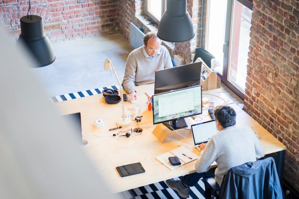 This photo features a productive work floor with overhead office lighting