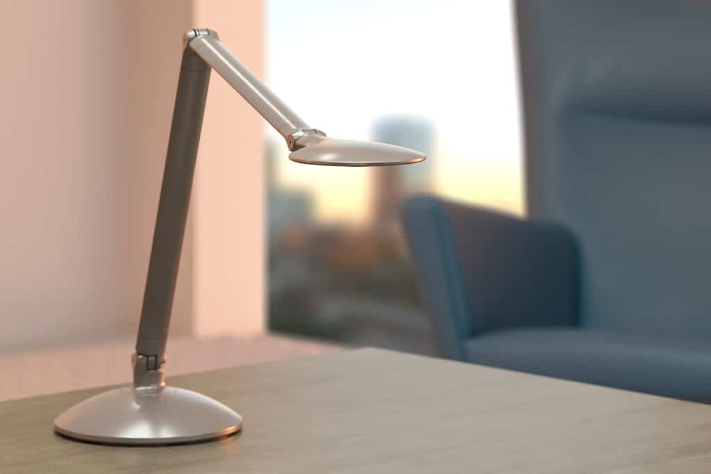 The image shows the Revo Double Arm Desk light on an office desk.