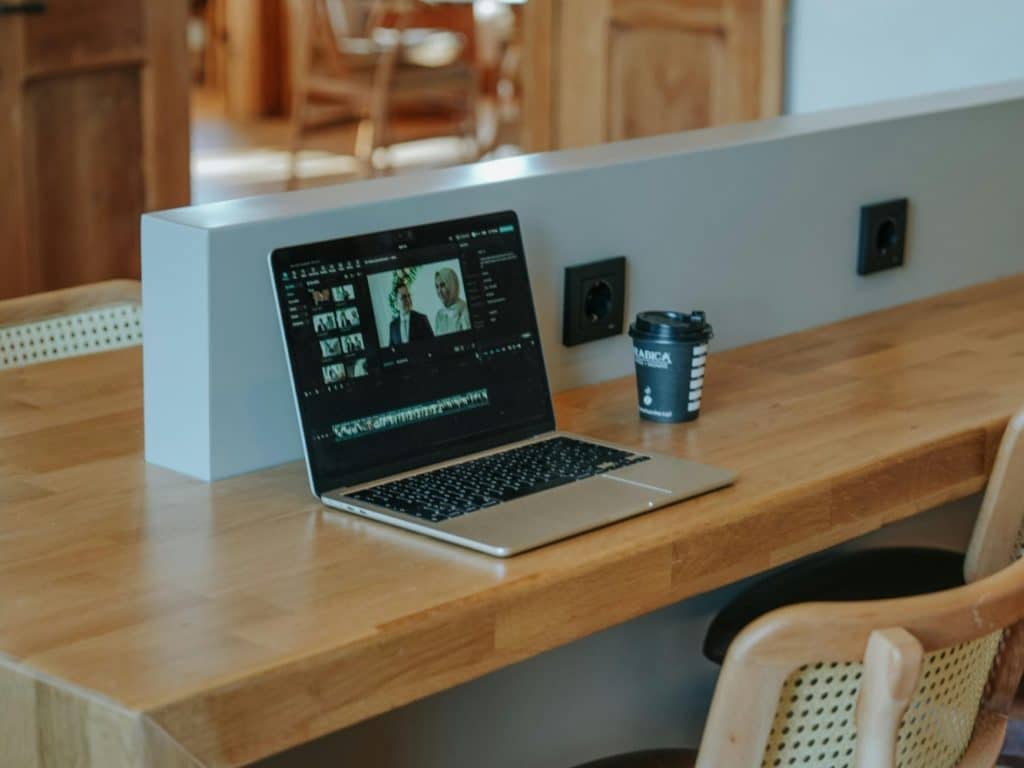 This photo features a laptop on a table with a recessed outlet