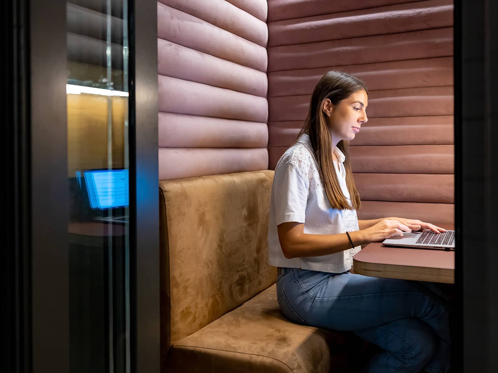 An office worker using a quiet pod to work